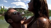 Two girls are outdoors by the water, taking in a bit of sun and cock