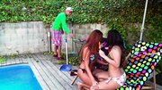 Two ladies are by the pool and they wait for the dude to join them