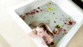 Scarlett Sage satisfies pussy in the bathtub with flowers